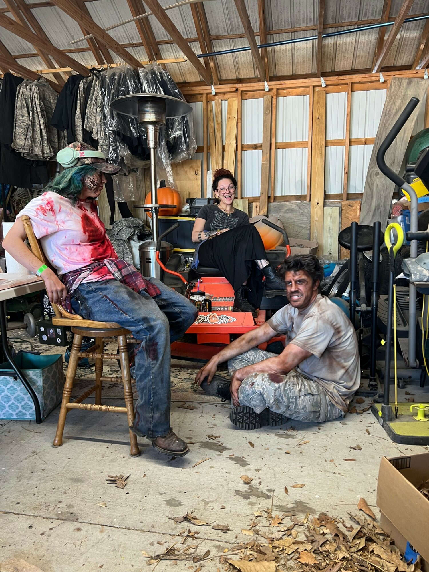 Two people working on a woodworking project in a workshop, with wood and tools around them.
