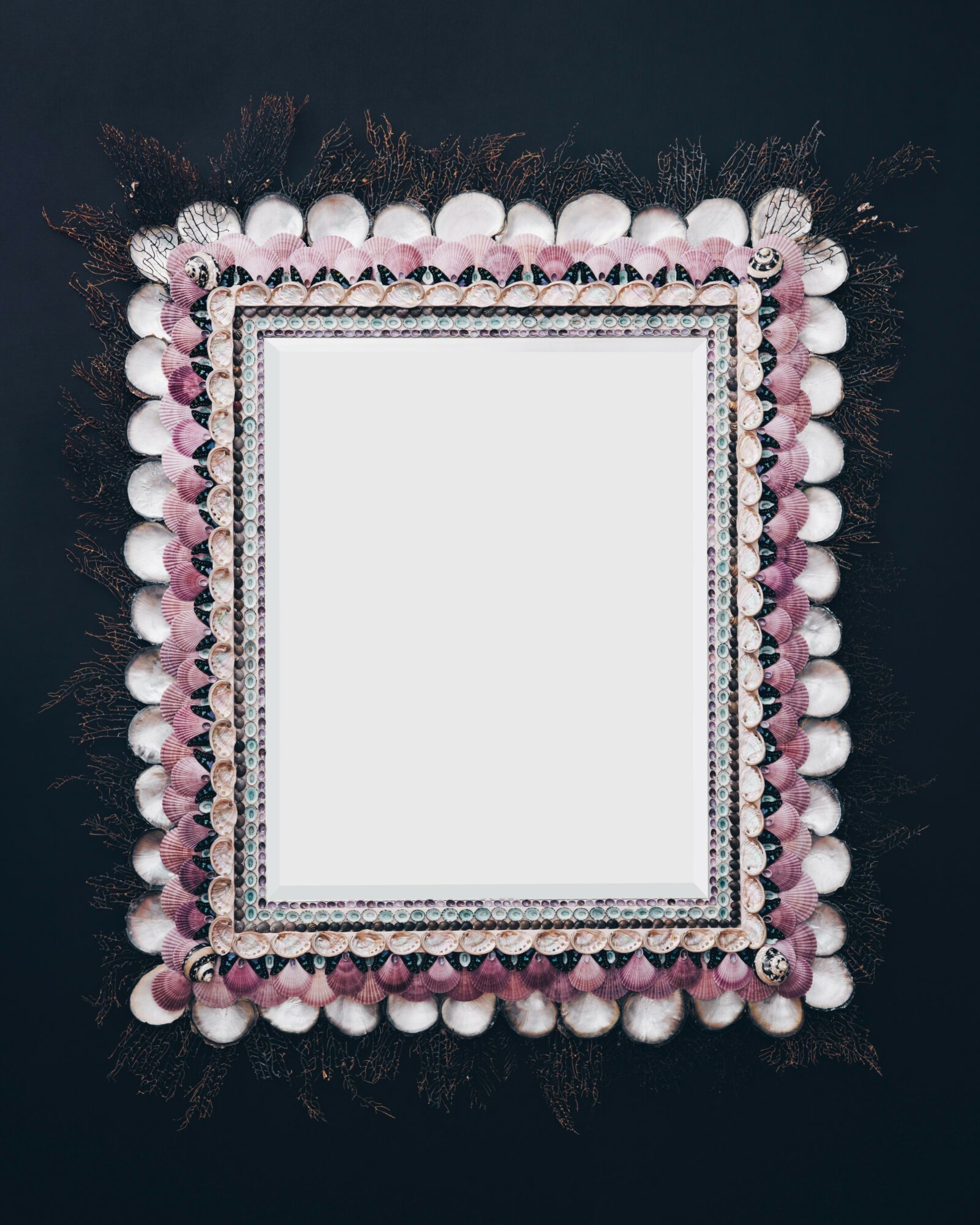 Decorative frame with pink, white, and black beads and pom-poms on a dark background, empty center for photo or message.