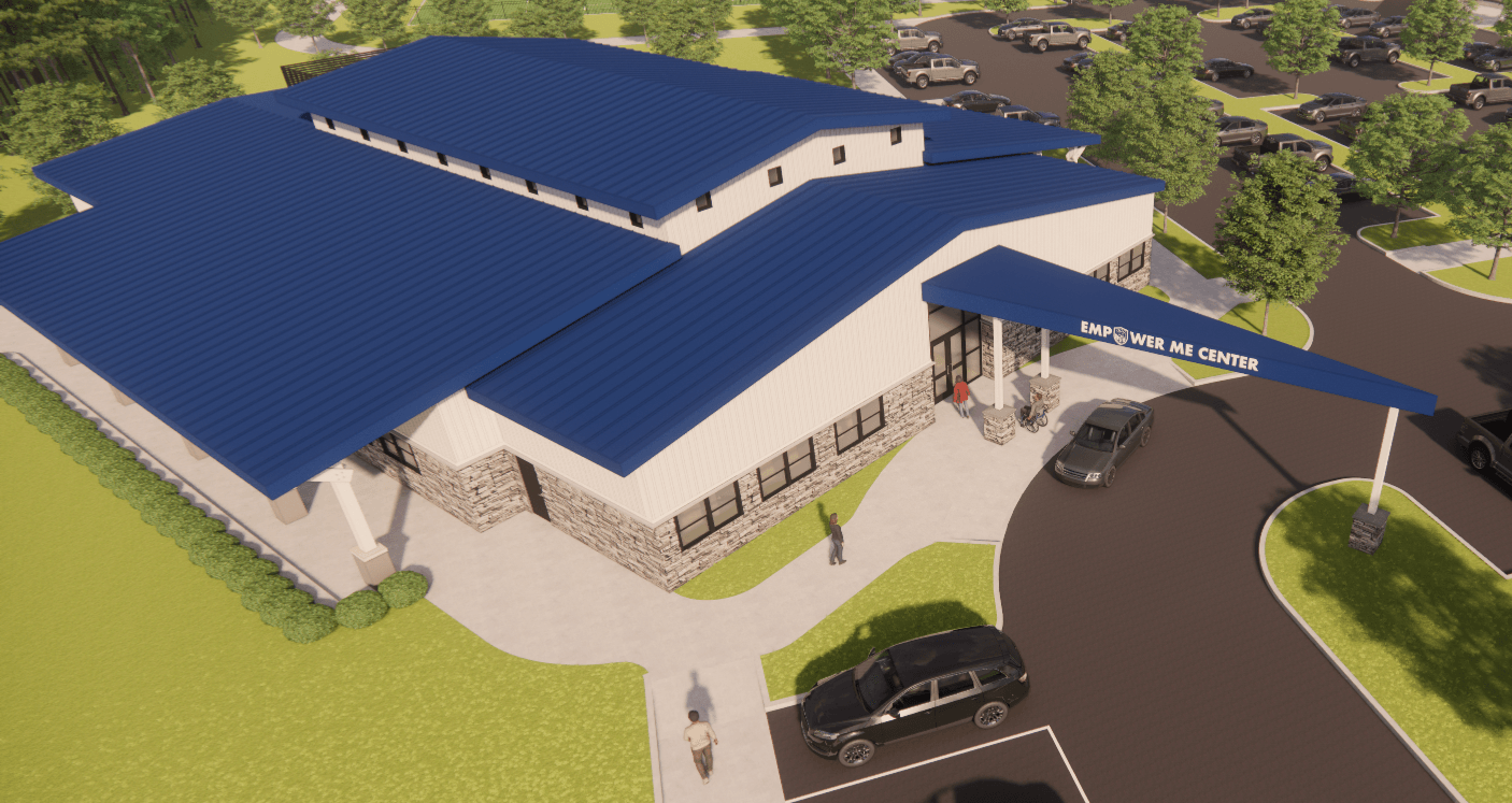 A large building with a blue roof labeled 'Community Center,' surrounded by parking and greenery.