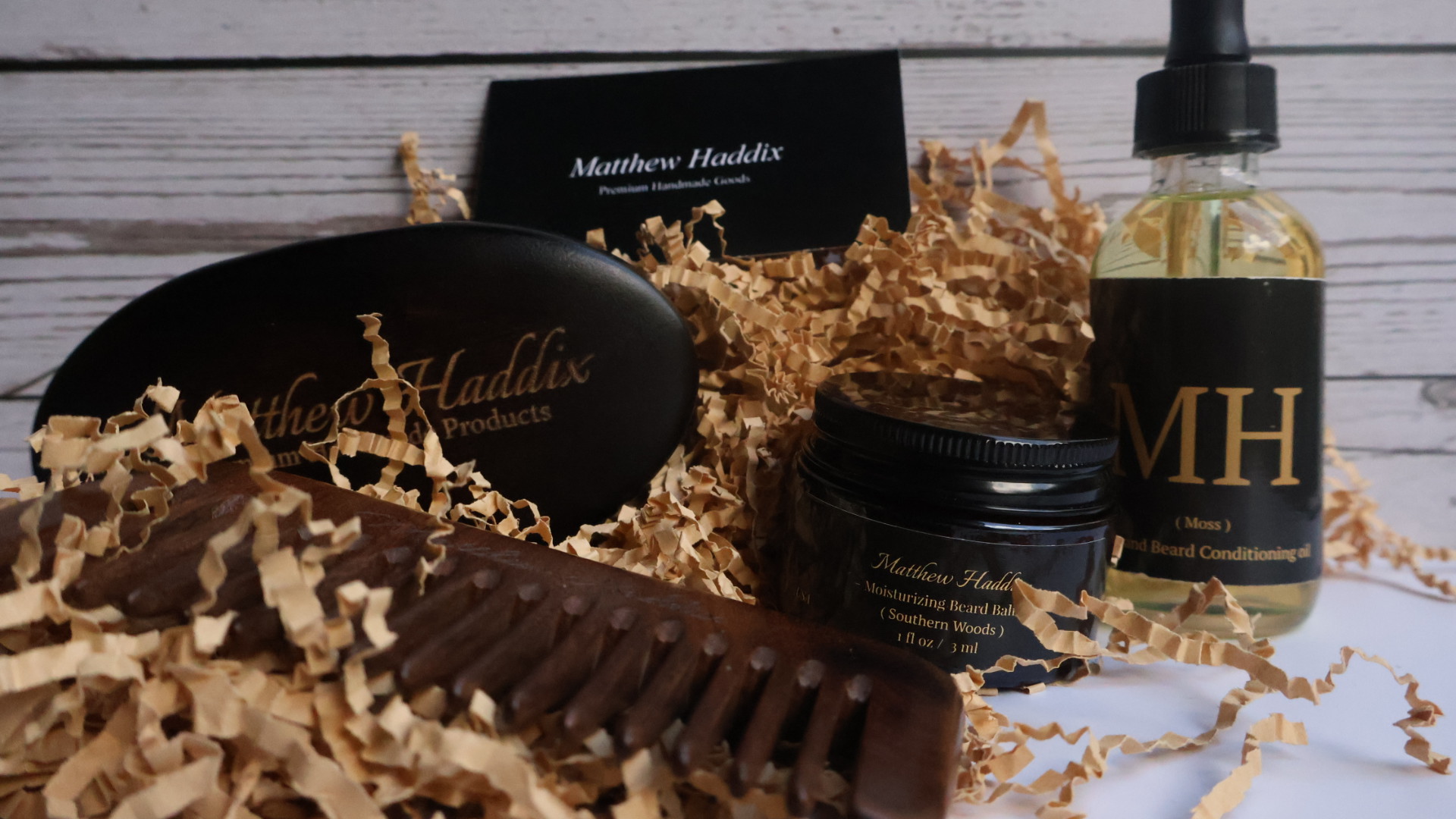 Collection of hair care products with black labels, surrounded by shredded paper and a wooden surface.