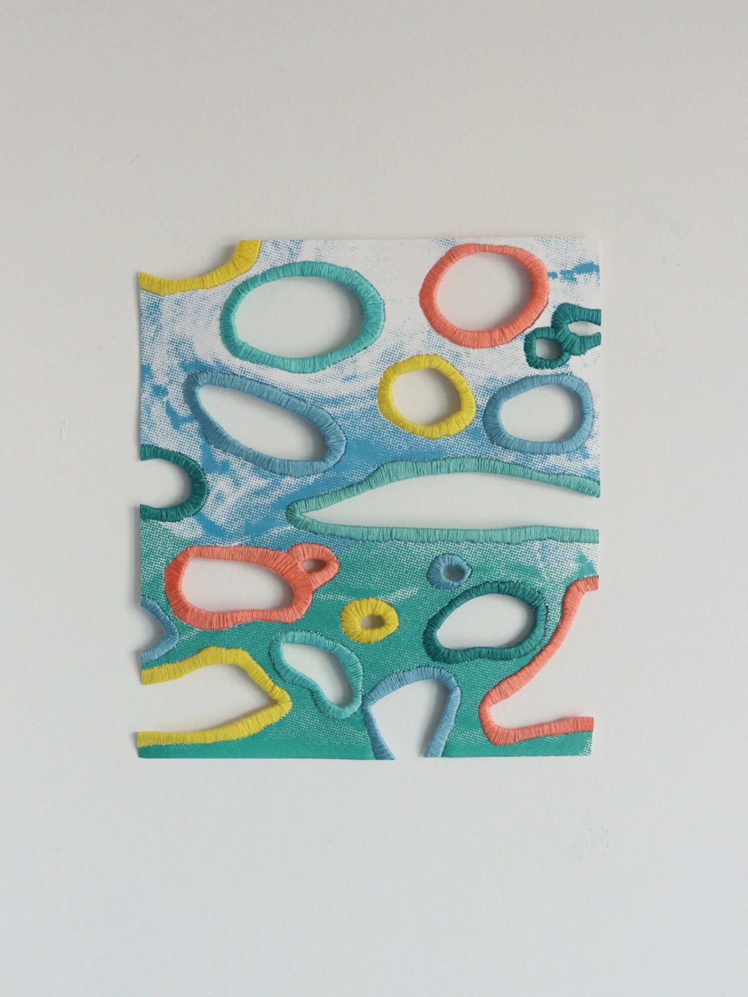 Colorful abstract paper with cut-out shapes on a white background.