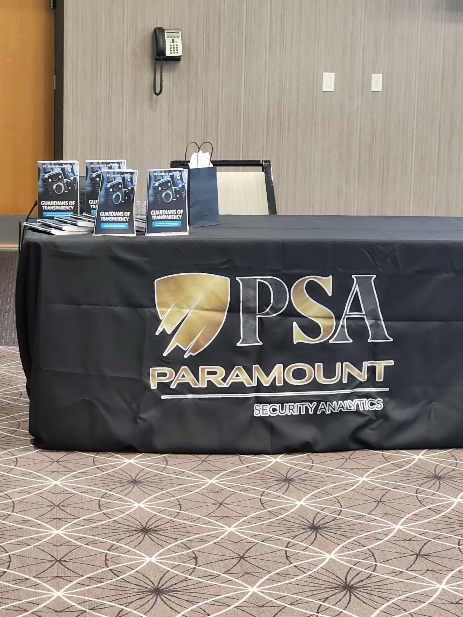 Table with a black Paramount Pictures and PS4 banner, three game cases, and a wall with electrical outlets.