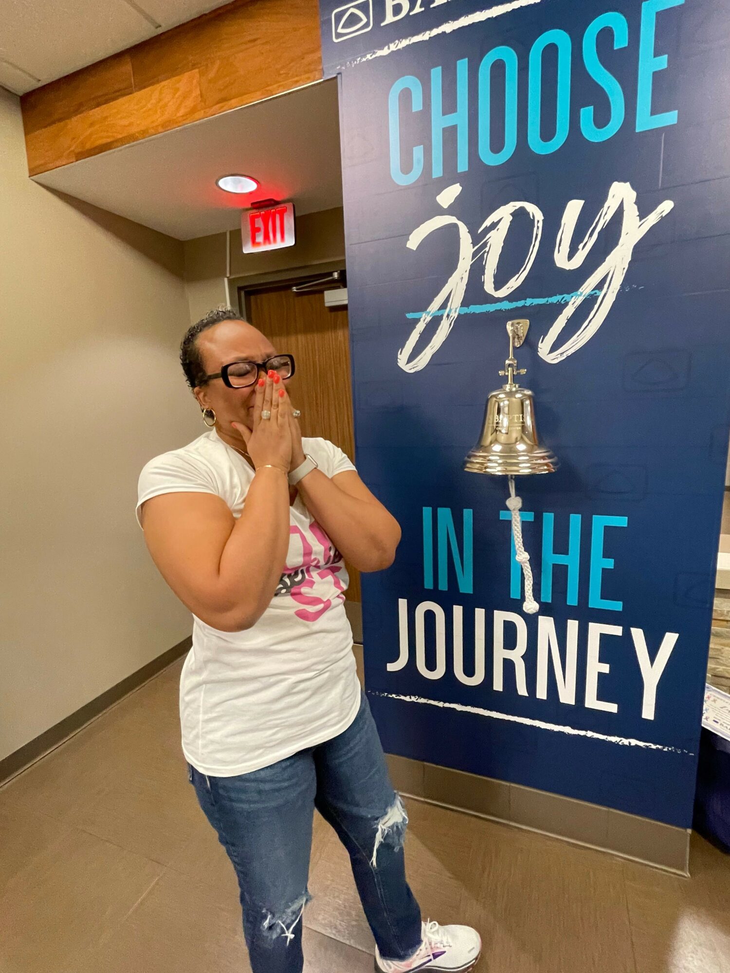 Woman with glasses and a white shirt stands next to a blue sign that reads 'Choose your journey'.