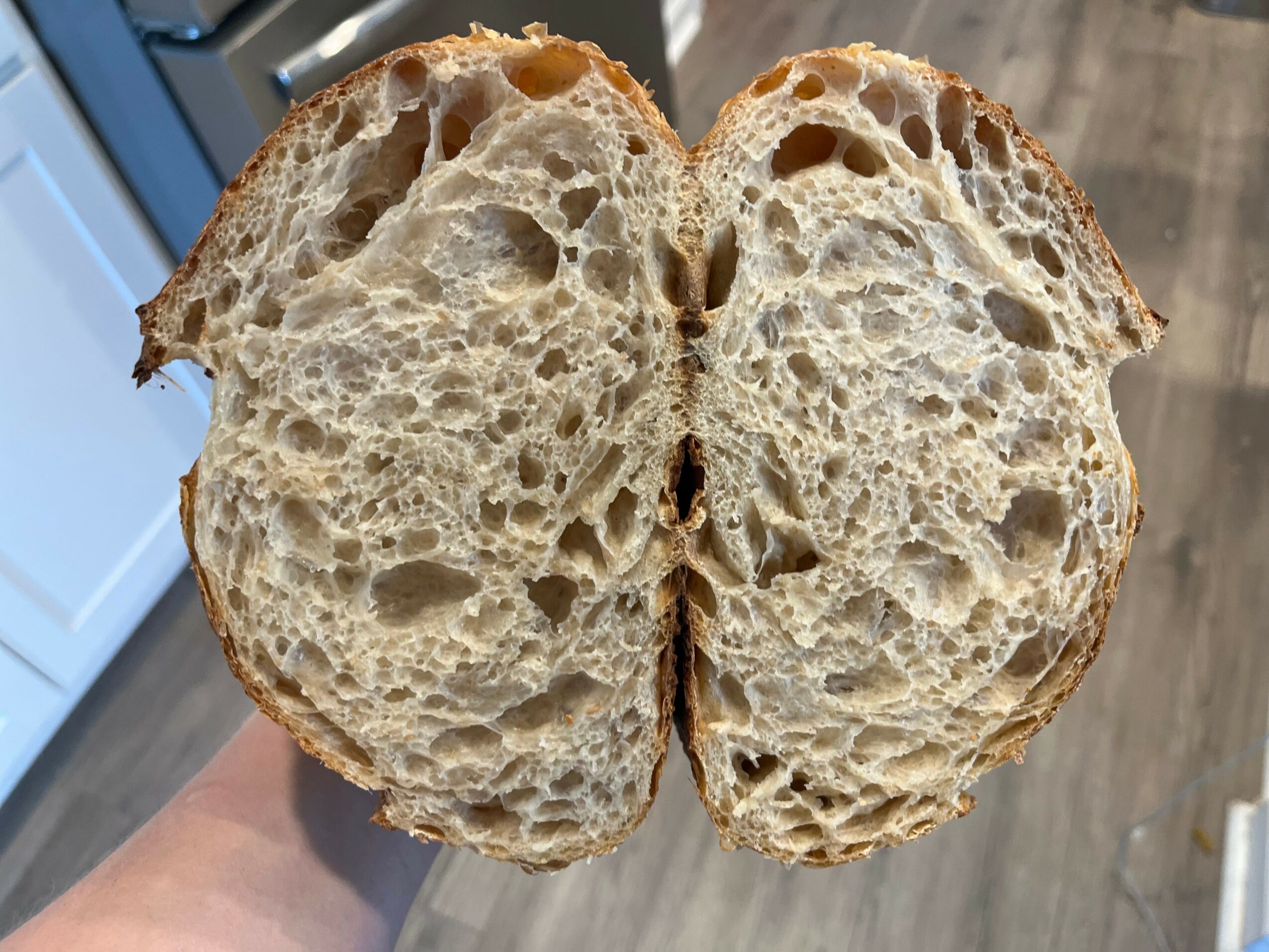 A sliced open loaf of bread showing a soft, airy interior with irregular holes.