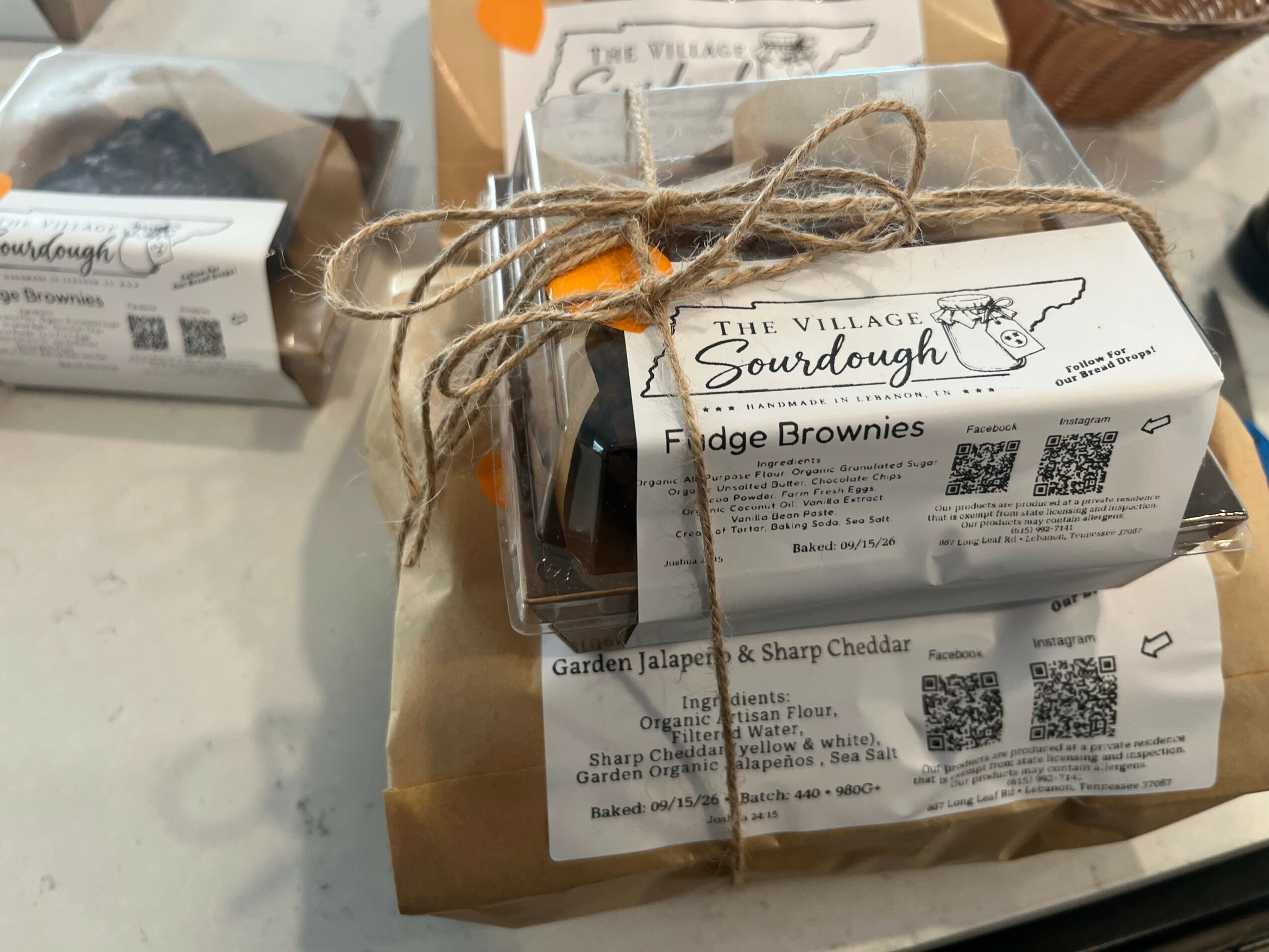 Packaged fudge brownies with a label, tied with twine, on a table surface.