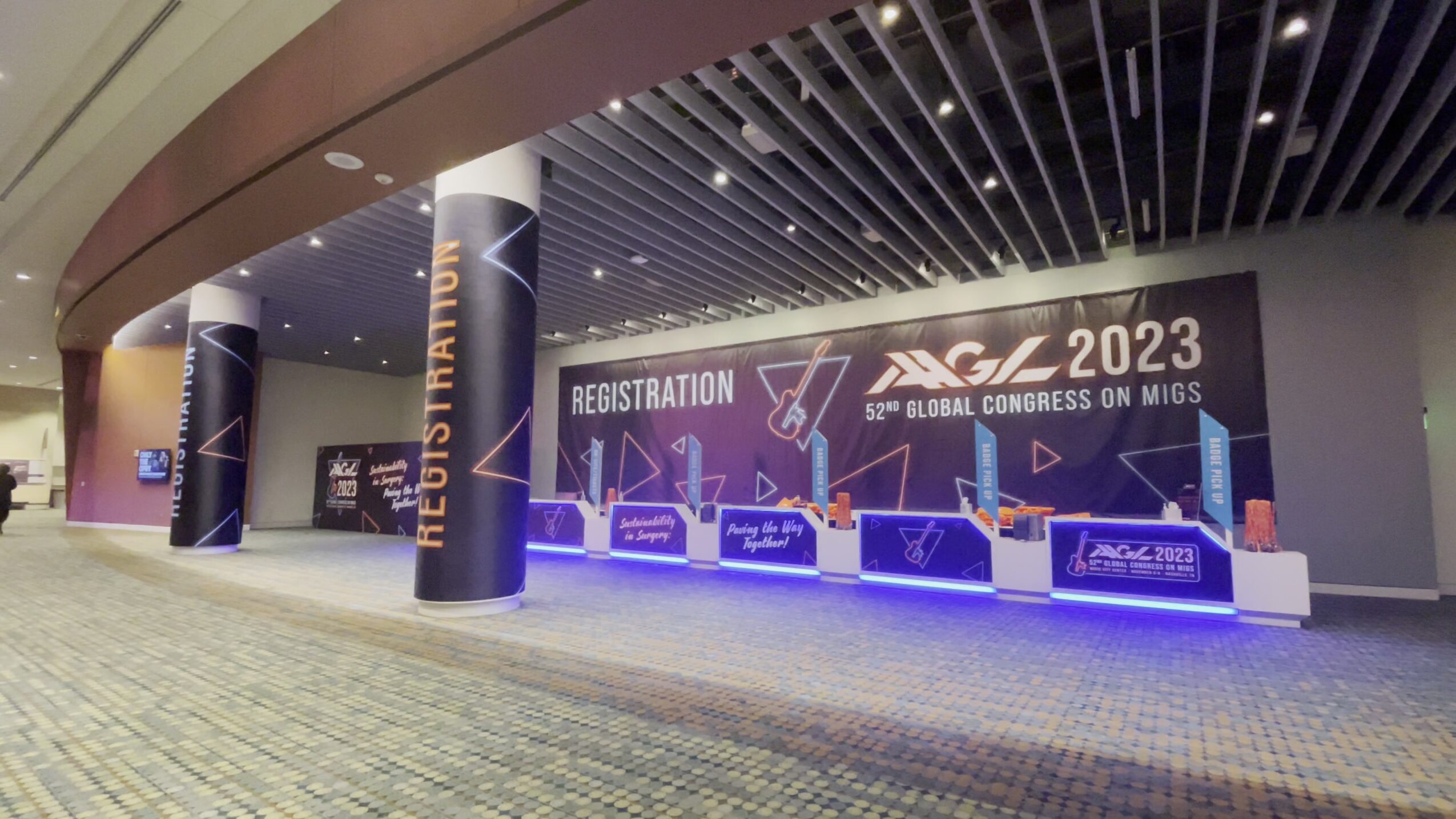Registration area for a conference with a large banner reading '2023' and 'Global Congress on MICS', with registration desks and signage.